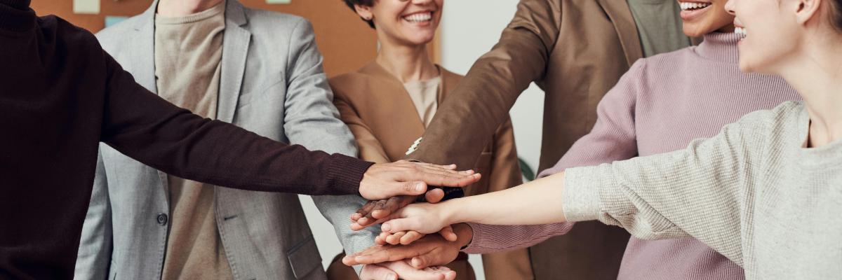 Group of people with their hands in the middle of the group